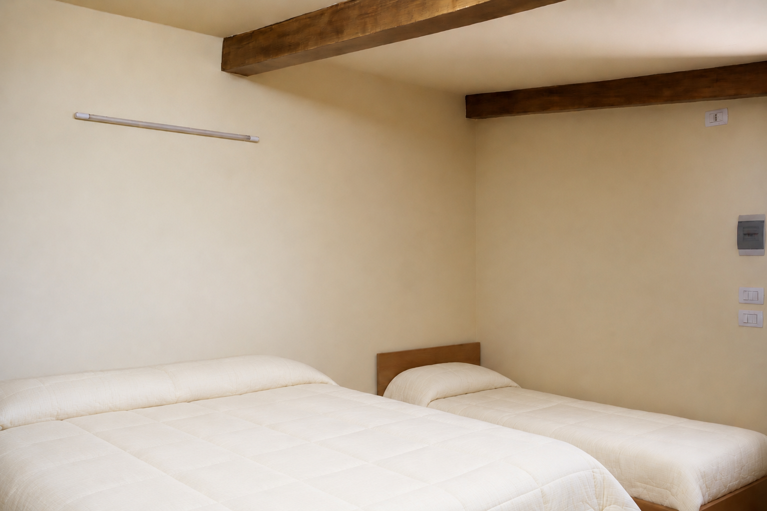 Camera primo piano di Casa Giufà con letto e soffitto in legno