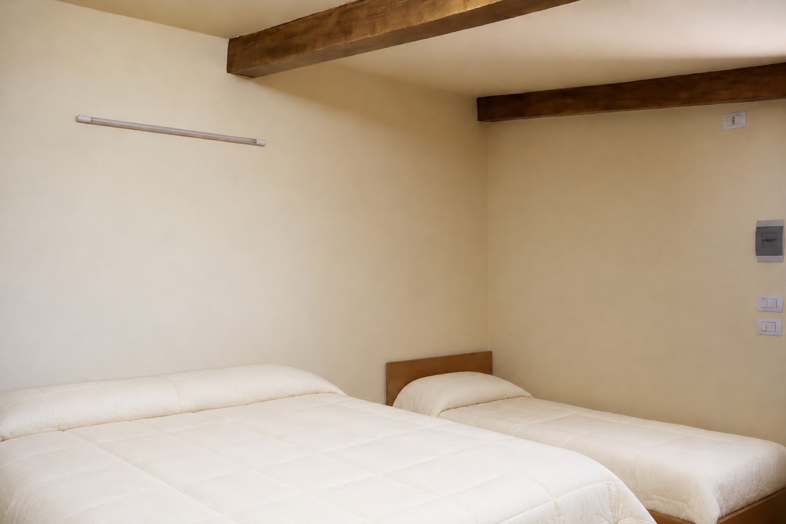 Camera primo piano di Casa Giufà con letto e soffitto in legno